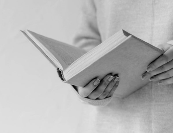 An employee reading a physical book from the klib library at their workplace